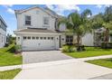 Two-story home featuring a manicured lawn, beautiful landscaping, and an attached two-car garage at 8822 Interlocking Ct, Davenport, FL 33896