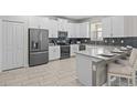 Well-equipped kitchen with stainless steel appliances, a breakfast bar, and modern white cabinetry at 8822 Interlocking Ct, Davenport, FL 33896