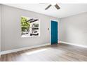 Bright bedroom showcasing wood-look flooring, a window and a stylish blue door at 1859 Matterhorn Dr, Orlando, FL 32818