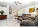 Bright living room featuring tile flooring, a ceiling fan, and comfortable seating at 11512 Clair Pl, Clermont, FL 34711