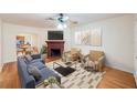 Staged living room featuring hardwood floors, a brick fireplace, modern furniture, and decor at 1225 Golfview St, Orlando, FL 32804