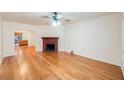 Spacious living room with hardwood floors, ceiling fan, and a brick fireplace at 1225 Golfview St, Orlando, FL 32804
