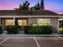 Charming brick condo featuring a well-maintained lawn and assigned parking spaces at 1230 Americana Pl, Orlando, FL 32807