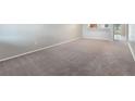 Empty living room with neutral carpeting and walls, offering a blank canvas for personalization at 1230 Americana Pl, Orlando, FL 32807