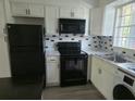 Contemporary kitchen with white cabinets, black appliances, and stylish backsplash at 1250 S Denning Dr # 108, Winter Park, FL 32789