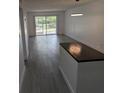 Bright open living room area, showing modern grey floors and access to the exterior at 1250 S Denning Dr # 108, Winter Park, FL 32789