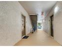 Hallway showing apartment entrance doors and a staircase with neutral walls and flooring at 1375 Tuscana Ln # 1102, Davenport, FL 33896