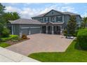 Beautiful home boasts a paver driveway, three-car garage, and well-manicured landscaping at 14357 United Colonies Dr, Winter Garden, FL 34787