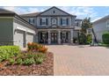 Charming two-story home with a paver driveway, three-car garage, and professionally landscaped yard at 14357 United Colonies Dr, Winter Garden, FL 34787