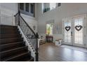 Elegant foyer featuring a staircase with wrought iron railing and decorative glass front doors at 14357 United Colonies Dr, Winter Garden, FL 34787