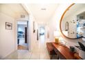 Inviting hallway featuring tile flooring, a round mirror, decorative console, and stylish accents at 1791 Hackberry St, Clermont, FL 34715