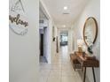 Inviting hallway featuring neutral-toned walls, a stylish console table and a decorative mirror at 1791 Hackberry St, Clermont, FL 34715