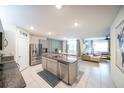 Open kitchen features stainless steel appliances, granite countertops, and a large island with bar seating at 1791 Hackberry St, Clermont, FL 34715
