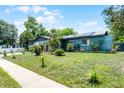 Exterior view of a single-story home with a well-maintained lawn, sidewalk, and mature landscaping at 1872 Wayside Dr, Orlando, FL 32818