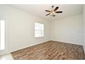 Bedroom with hardwood floors, neutral walls, ceiling fan with light fixture, and an abundance of natural light at 1947 Vienna Ave, Deltona, FL 32725