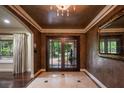 Elegant foyer features tile flooring, a decorative mirror, and a glass-paneled double front door at 2009 Woody Dr, Windermere, FL 34786