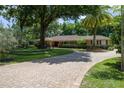 Beautiful brick home with well-manicured lawn and elegant circular driveway entrance at 2009 Woody Dr, Windermere, FL 34786