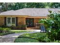 Inviting brick home exterior with manicured landscaping and cozy front porch seating at 2009 Woody Dr, Windermere, FL 34786