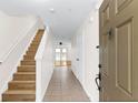 Inviting entryway featuring neutral-toned walls, tile floors, and wood stairs leading to the upper level at 221 Sterling Springs Ln, Altamonte Springs, FL 32714