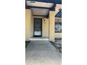 Home's entrance with secure door, concrete pathway, and visible house number above the doorway at 2235 Silver Pines Pl # 401, Orlando, FL 32808