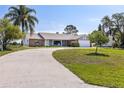 Well-maintained single-story home with a circular driveway and lush green lawn at 2562 Sheffield Dr, Deltona, FL 32738