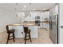 Bright kitchen featuring white cabinetry, stainless steel appliances, a breakfast bar with seating, and tiled floors at 3018 Bargate St, Orlando, FL 32824