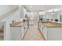 Galley kitchen with white cabinets, granite countertops, stainless steel appliances, and a tiled floor at 3018 Bargate St, Orlando, FL 32824