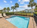 Inviting in-ground pool and spa with brick surround, metal fence and view of neighborhood homes at 3020 Parrot Head Pl, Kissimmee, FL 34747