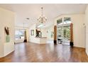 Spacious living room featuring wood-look flooring, a decorative chandelier, and sliding glass doors to a screened in porch at 3029 Bransbury Ct, Kissimmee, FL 34747