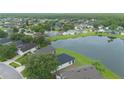 An aerial view showcasing the neighborhood's homes by a serene lake surrounded by lush green landscapes and trees at 3128 Stonehurst Cir, Kissimmee, FL 34741