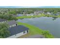 An aerial view showcasing the neighborhood's homes by a serene lake surrounded by lush green landscapes and trees at 3128 Stonehurst Cir, Kissimmee, FL 34741