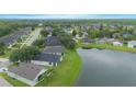 Scenic aerial of neighborhood homes bordering a lake with lush trees and greenery, offering peaceful waterfront living at 3128 Stonehurst Cir, Kissimmee, FL 34741