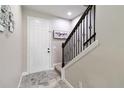 Bright entryway featuring stylish gray tile flooring, staircase with dark wood and iron railing, and modern decor at 3883 Crawley Down Loop, Sanford, FL 32773