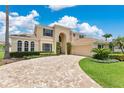 Beautiful home with lush green lawn and palm trees, featuring a circular paver driveway leading to an attached two-car garage at 4221 Kezar Ct, Belle Isle, FL 32812