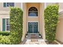 Inviting front entrance with double doors, flanked by symmetrical greenery and adorned with wreaths, creating a welcoming ambiance at 4221 Kezar Ct, Belle Isle, FL 32812