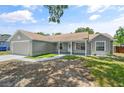 Inviting single-story home showcasing a covered porch and fresh landscaping at 5160 Wood Ridge Ct, Ocoee, FL 34761