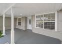 The home's covered porch has white columns, gray brick base, neutral siding and a decorative door at 5160 Wood Ridge Ct, Ocoee, FL 34761
