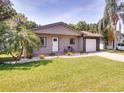 Inviting single Gathering home featuring a green lawn, established landscaping, and a quaint front porch at 5216 Sunrise Blvd, Orlando, FL 32803