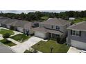 Two-story home shows large driveway, well-manicured lawn and covered porch at 5350 Pine Lilly Dr, St Cloud, FL 34771