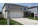 Inviting two-story home featuring an attached two-car garage and well-maintained front yard at 5350 Pine Lilly Dr, St Cloud, FL 34771