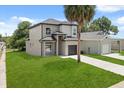 A gray two-story home with a one-car garage and a spacious lawn, complete with a driveway at 811 E Mcdonald Ave, Eustis, FL 32726