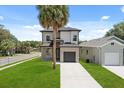 A gray two-story home with a one-car garage, a well-kept lawn, and a paved driveway at 811 E Mcdonald Ave, Eustis, FL 32726
