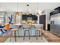 Stylish kitchen boasts dark cabinets, granite countertops, and island seating with pendant lighting at 8256 Bayview Crossing Dr, Winter Garden, FL 34787