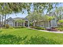 Beautifully landscaped single-Gathering home with a lush green lawn, mature trees, and well-maintained exterior at 8612 Summerville Pl, Orlando, FL 32819