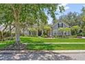 Inviting single-Gathering home with lush green lawn, mature trees, and colorful landscaping at 8612 Summerville Pl, Orlando, FL 32819