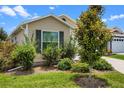 Well-maintained home with a window, landscaping, and green grass at 6231 Atkinson Ln, The Villages, FL 32163