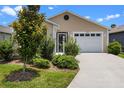 Inviting home with an attached garage, lush green bushes, and a well-manicured lawn at 6231 Atkinson Ln, The Villages, FL 32163