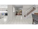 Hallway with stairs leading to an open living room and kitchen area with bright tile floors at 103 Odin Dr, Winter Haven, FL 33884