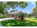 Lovely home exterior featuring an attached three-car garage, mature landscaping, and a well-maintained lawn at 1515 Cherry Lake Way, Lake Mary, FL 32746