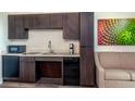 A modern kitchenette features sleek cabinets, stainless steel appliances, and a cozy breakfast bar at 15695 Grove Resort Ave # 4238, Winter Garden, FL 34787